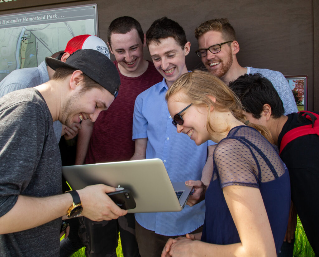 Seven students watching a video on at a laptop at Hovander Homestead Park in Ferndale, Washington, on May 4, 2017.