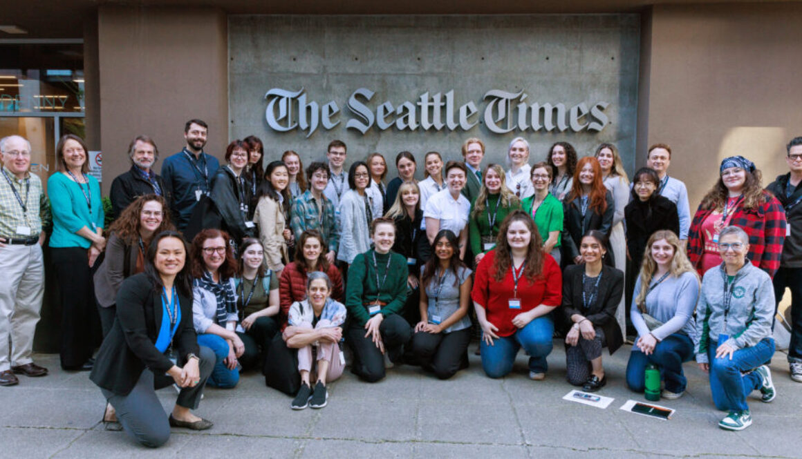 group of 39 journalists, educators, and students pose for a picture in front of The Seattle Times building.