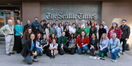 group of 39 journalists, educators, and students pose for a picture in front of The Seattle Times building.