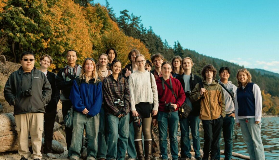 Students in the WWU Photo and Video Club smile for the camera at the beach.