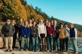 Students in the WWU Photo and Video Club smile for the camera at the beach.