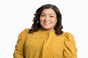 A woman smiles against a white backdrop.