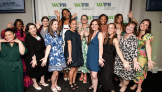 Many women smile and pose for the camera.